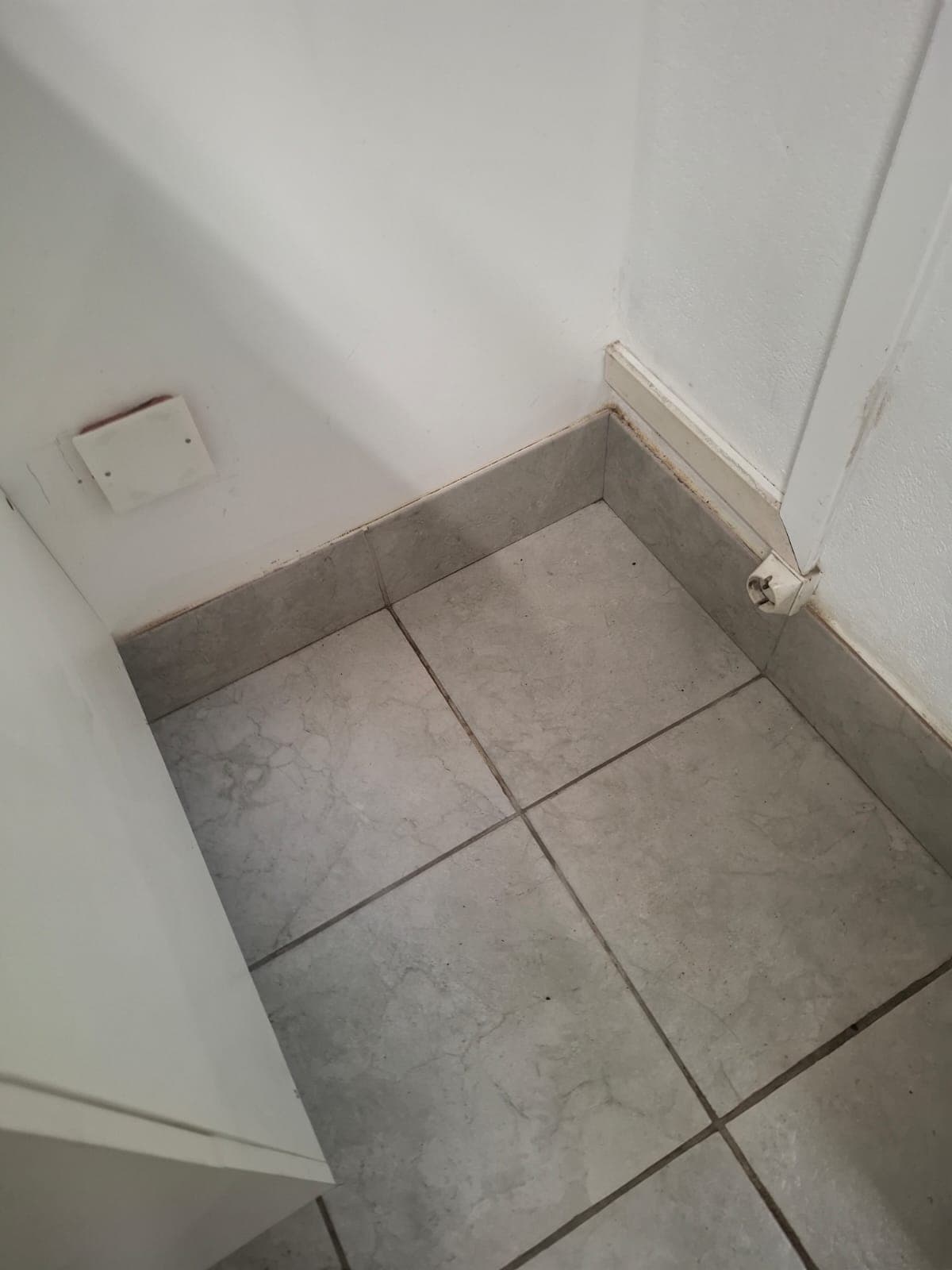 Le même angle après passage : carrelage clair, plinthes essuyées et sol dégagé